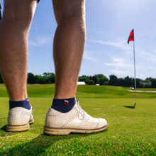 Golfer standing on the green, wearing Midnight Blue Stars and Stripes Ankle socks.